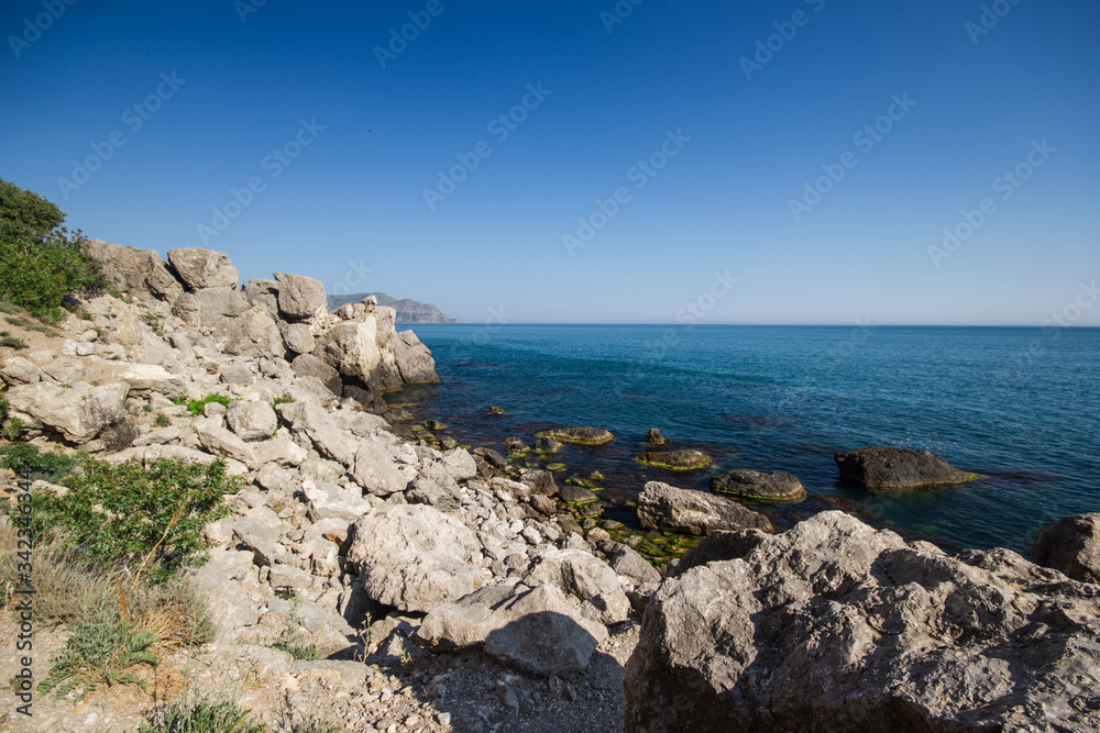 Travel in Crimea, Russia. Nature background. Colorful landscape with blue sea, mountains, rocks and sunlight in clear warm summer cloudless day. Concept of vacation on the coast