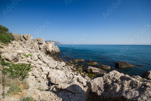 Travel in Crimea, Russia. Nature background. Colorful landscape with blue sea, mountains, rocks and sunlight in clear warm summer cloudless day. Concept of vacation on the coast © Marina Biryukova