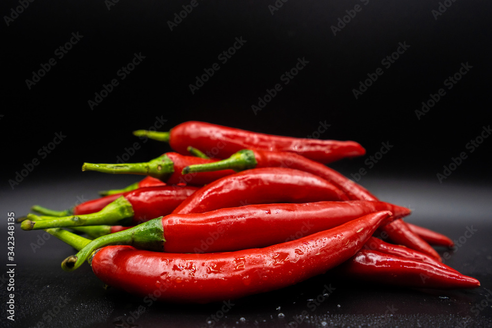 Many hot peppers on a black background