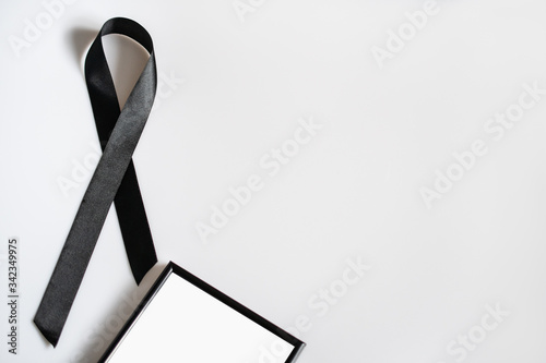 Black frame with space for text and a mourning ribbon on a white background photo