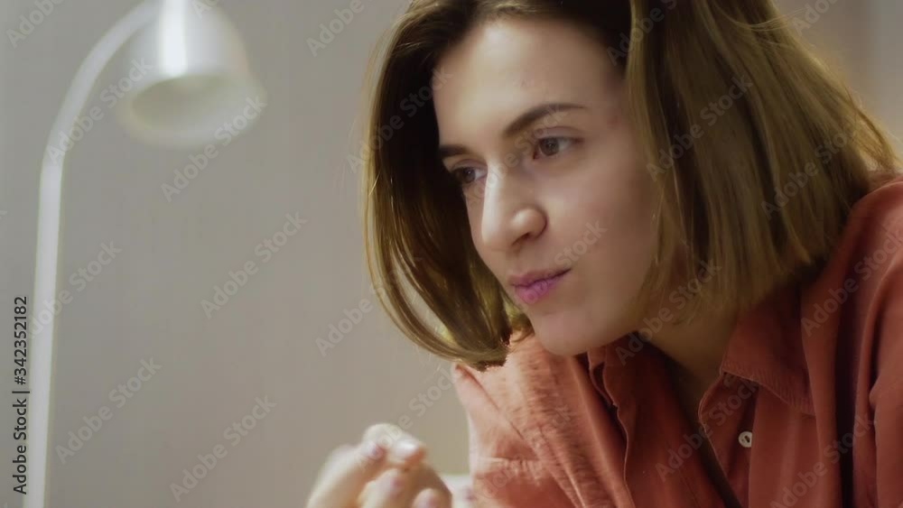 Young woman sitting on the sofa, eating popcorn and watching TV Young woman sitting on the sofa, eating popcorn and watching TV