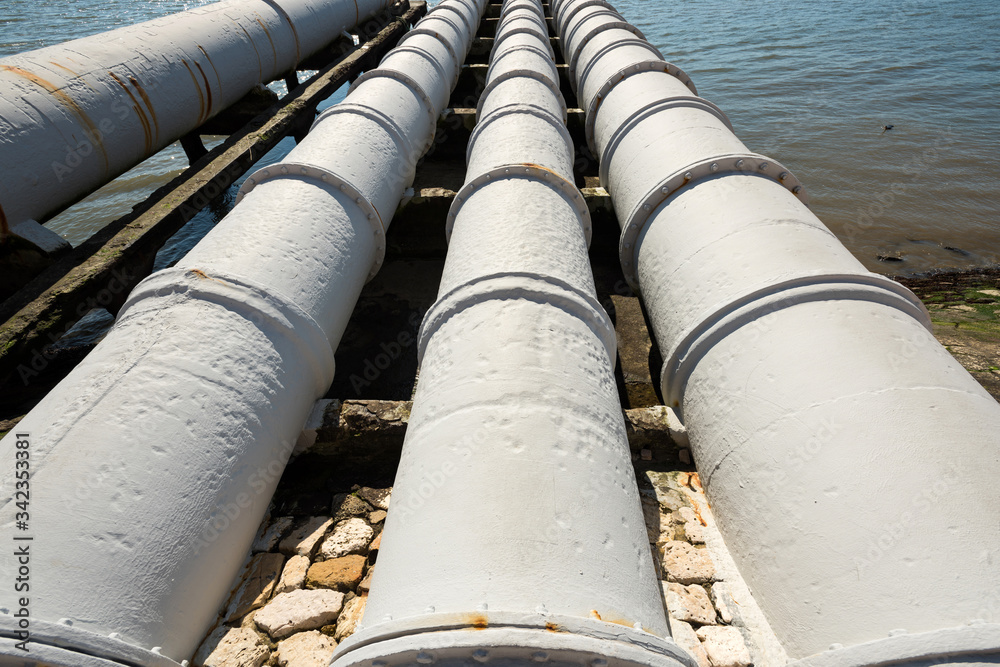 Industrial pipes near power station, feeding into the river. Environmental pollution concept. Industrial pipes near power station, feeding into the river. Environmental pollution concept.