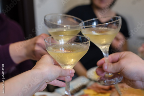 Friends and family people hands toasting white wine at the festive table