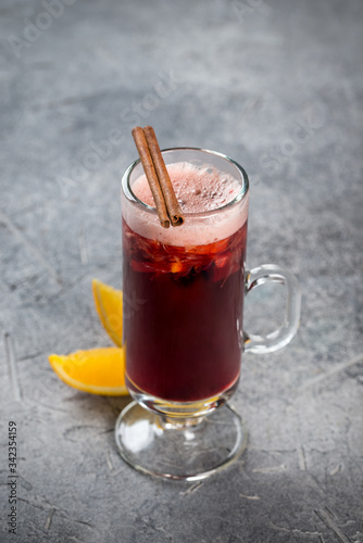 Mulled wine in a glass, tall, transparent glass with cinnamon and lemon