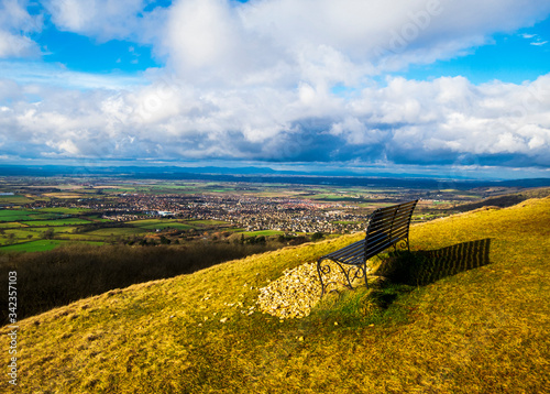 View across the evesham vale from Cleeve Hill in the Cotswolds Gloucestershire to the Malvern Hills in Worcestershire. photo