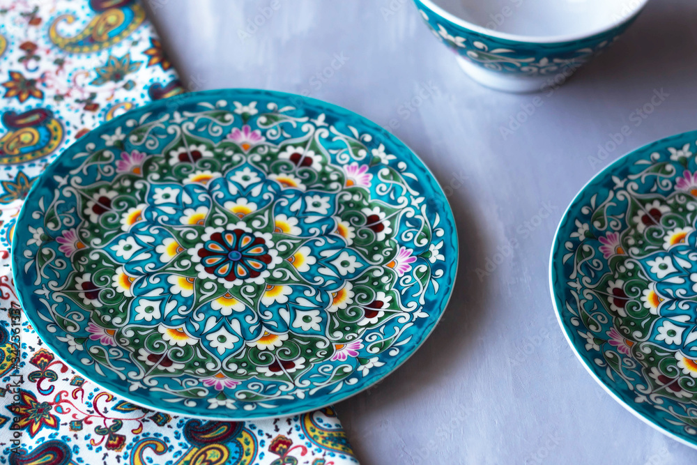 on the table there is a tableware with a national oriental pattern on the table there is a tableware with a national oriental pattern