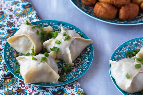 manti in a plate with a national pattern, Uzbek dishes, oriental cuisine photo