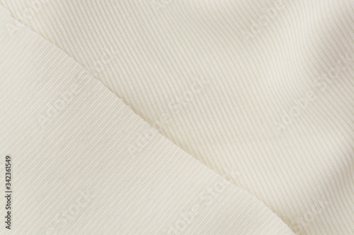 Corduroy background in close up. Texture of cream corduroy textile - useful as background