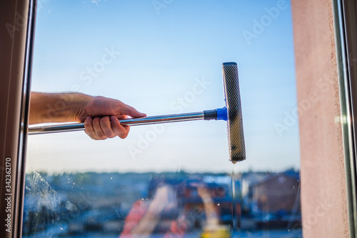 Window cleaning in high-rise buildings, houses with a brush. Window cleaning brush. Large window in a multi-storey building, cleaning service. Dust removal and glass washing.