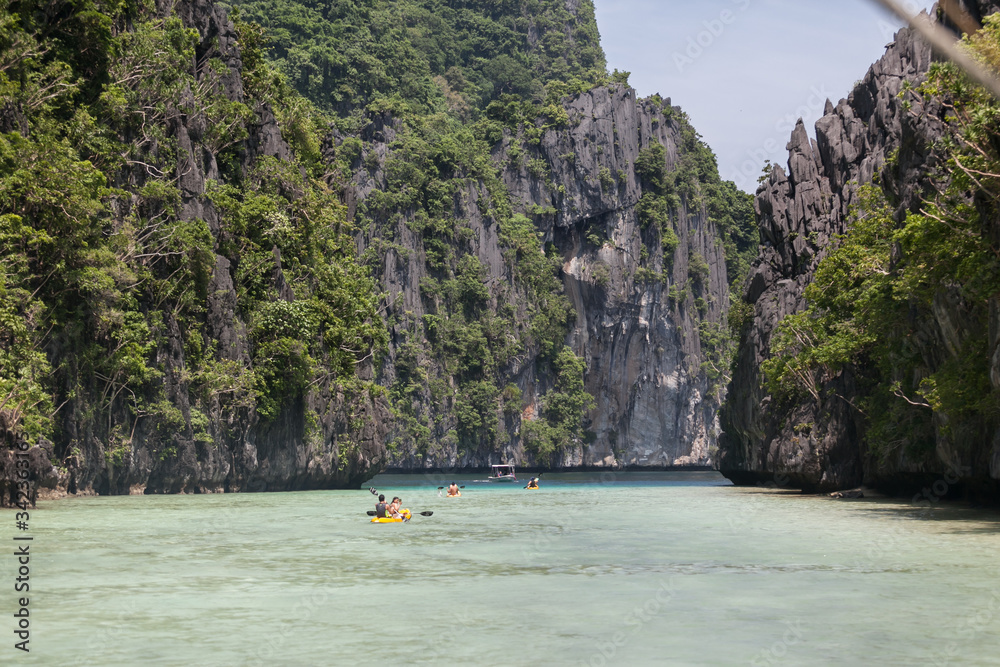 kayaking in clear water of paradise blue lagoon turquoise ocean limestone rocks