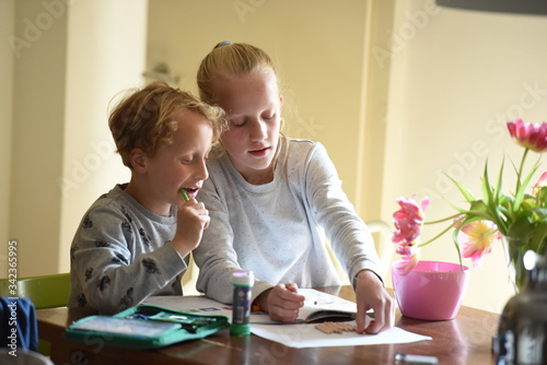 Mädchen hilft kleinem Bruder bei den Hausaufgaben