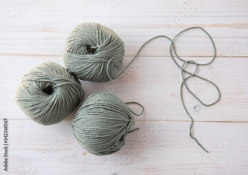 Knitting threads on a dark light wooden background.