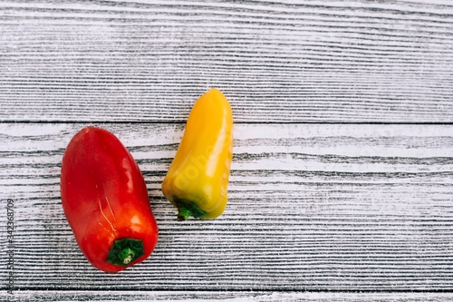 Red and yellow peppers on a white table. Fruits and vegetables on a wooden background. Food photography 