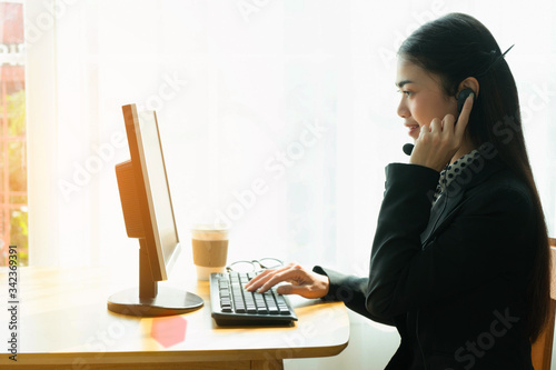 Businesswoman call center consultant with headsets in office with sunlight 