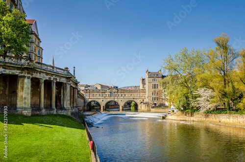 Landscape of the River Avon with Pulteney Bridge and the weir in the city of Bath, Somerset, UK on a clear and sunny Spring morning photo