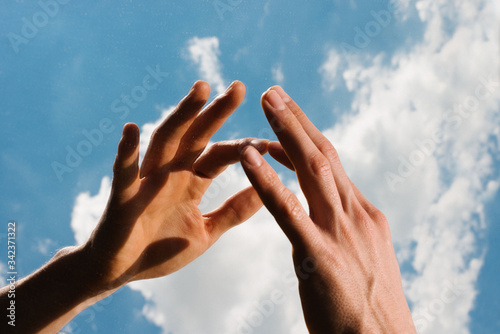 Close up of hands against cloudy sky