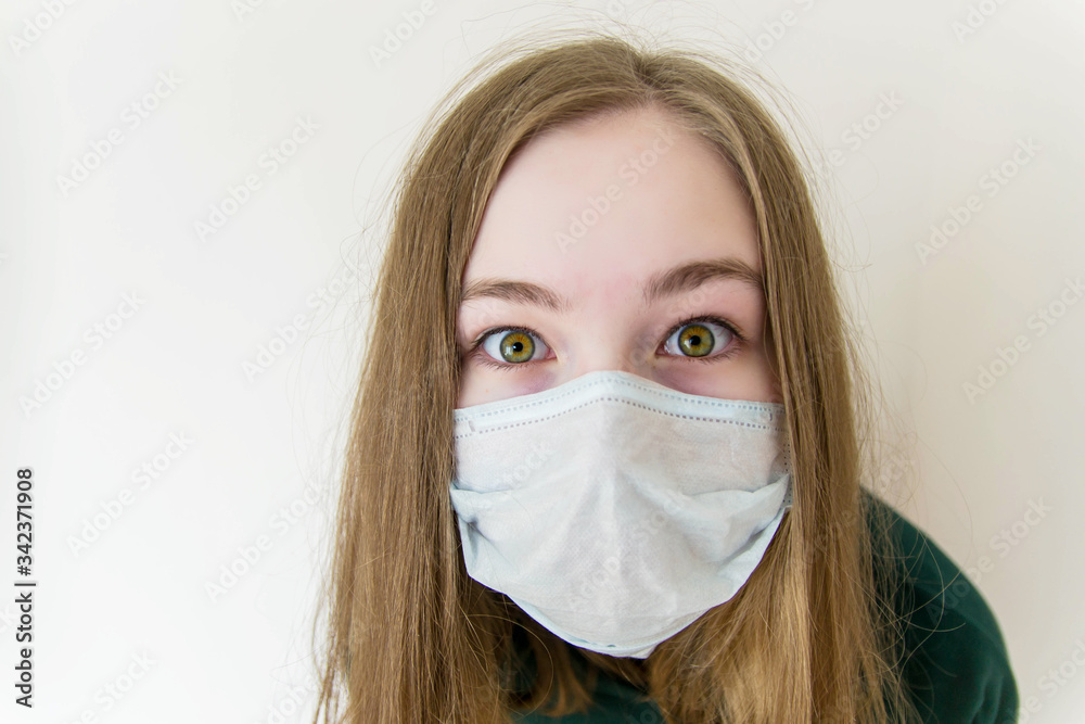 Girl in a medical mask closeup surprised, bulging, scared eyes. Girl in a medical mask closeup surprised, bulging, scared eyes.