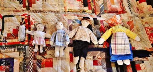 Fotografiet Five Toy Dolls On Patchwork Quilt