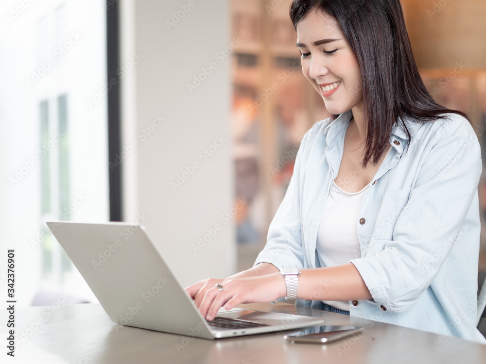 Asian woman happy using laptop sitting in room work from home. Technology and communication Asian woman happy using laptop sitting in room work from home. Technology and communication
