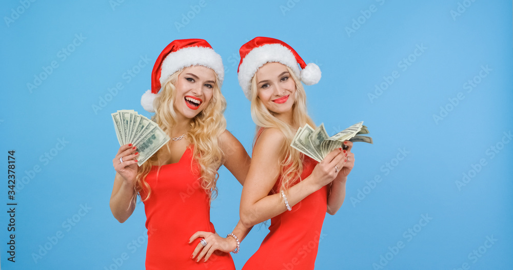 Obraz premium The twin sisters in Santa hats won a lot of money in the lottery.