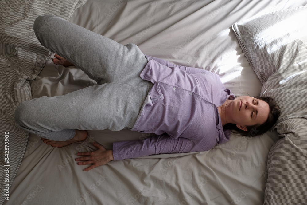 Young woman in ardha chakrasana yoga pose on bed in the morning Young woman in ardha chakrasana yoga pose on bed in the morning