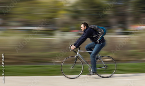 Young man riding to work on a bicycle.  © belyaaa