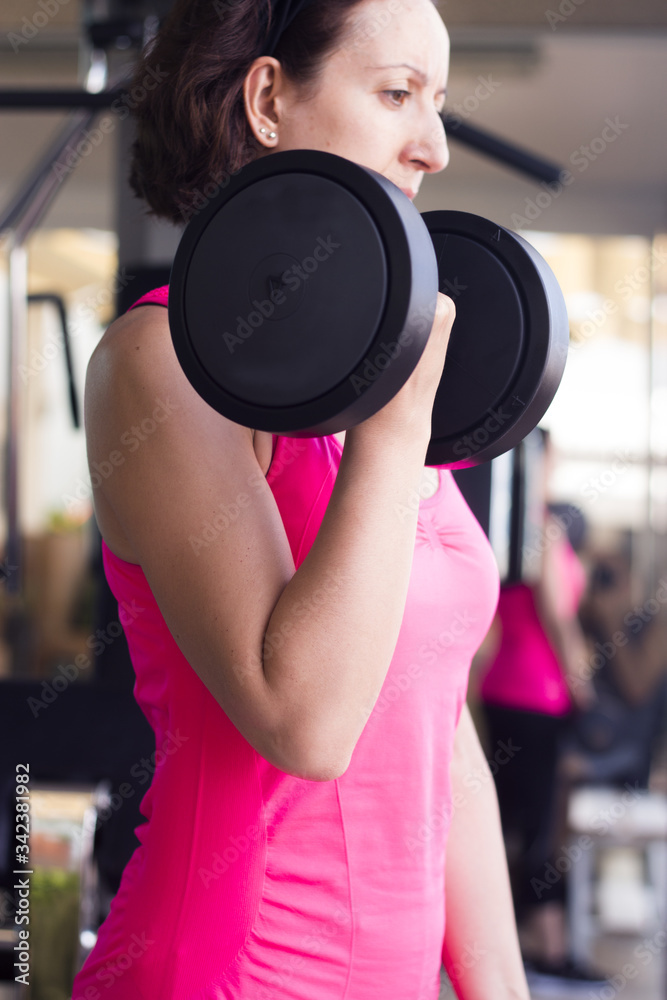 Thin thirties woman doing exercise in the gym Thin thirties woman doing exercise in the gym