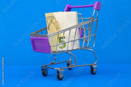 trolley with money on a blue background