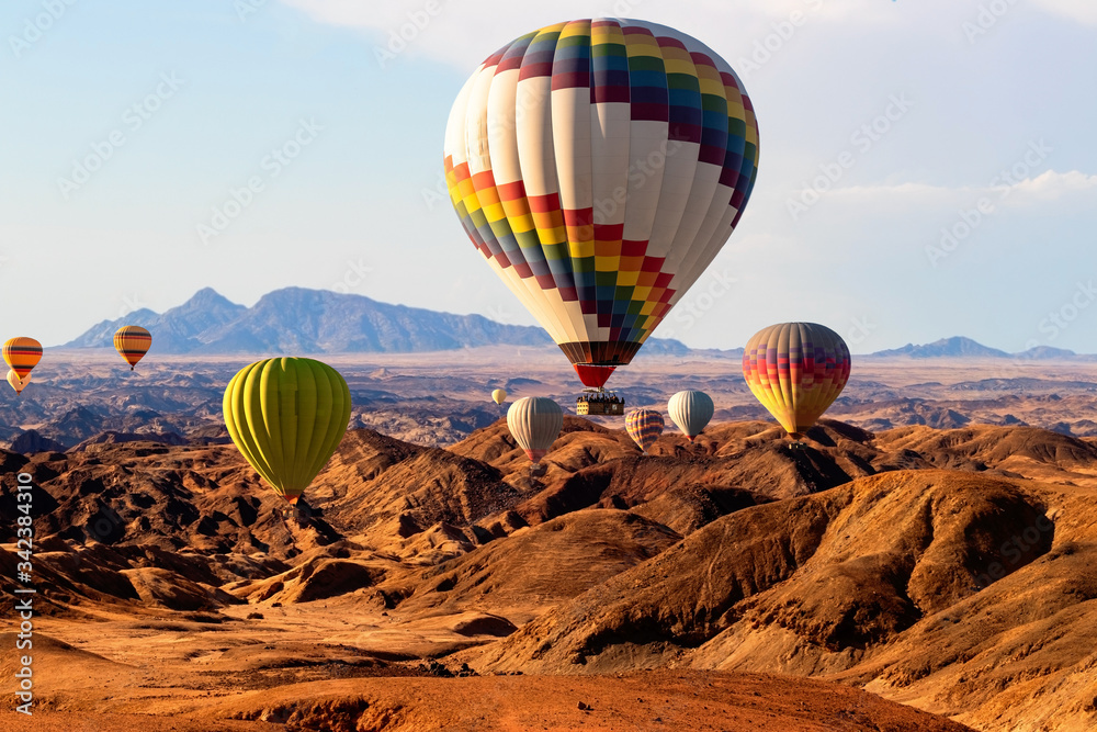 Obraz premium Colorful hot air balloons flying over the moon valley mountain. Africa. Namibia.