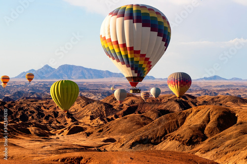 Colorful hot air balloons flying over the moon valley mountain. Africa. Namibia.