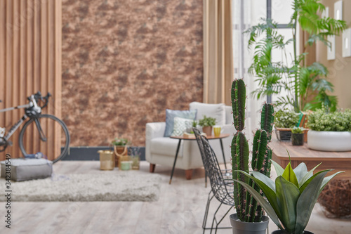 Decorative brown interior room, wooden bookcase background, grey armchair, coffee table and parquet detail.