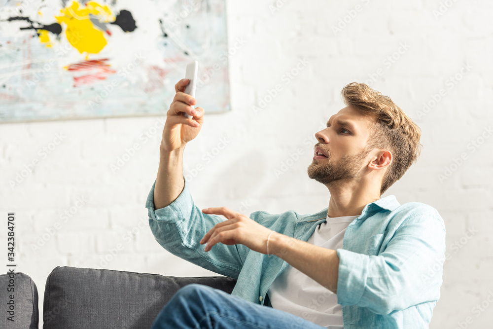 Handsome man using smartphone in living room Handsome man using smartphone in living room