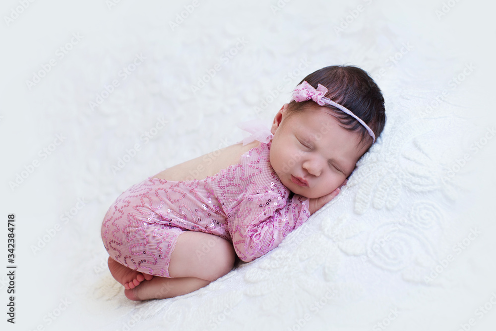 Newborn baby girl in pink sleeping on her stomach Newborn baby girl in pink sleeping on her stomach