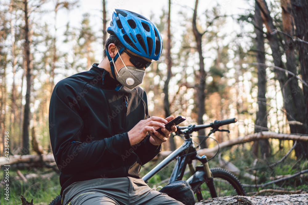 Cyclist wearing pollution mask. Young guy in respirator with filter pm 2.5  with bike in park. Covid 19 Quarantine Sports. Flu epidemic, dust allergy,  protection virus. Covid 19 virus concept Stock Photo | Adobe Stock