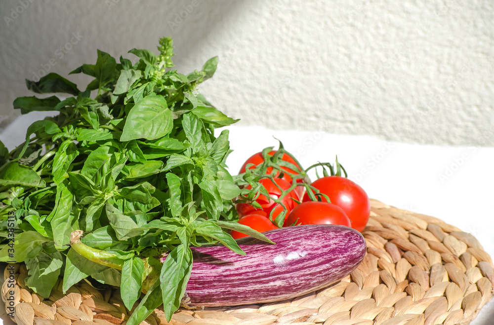 Raw vegetables close up. Vegetables on table against background of white wall. view of fresh tomatoes, basil, eggplant, red pepper. Healthy eating concept. Selective focus image. Raw vegetables close up. Vegetables on table against background of white wall. view of fresh tomatoes, basil, eggplant, red pepper. Healthy eating concept. Selective focus image.