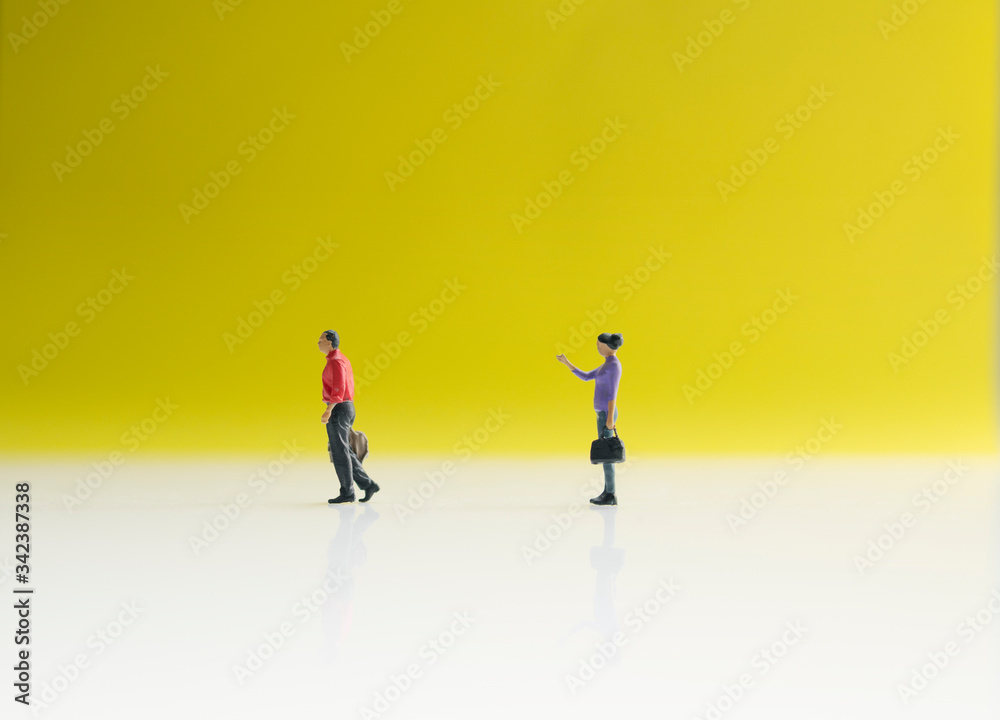 Two mini figure of businessman and businesswomen with yellow background. Business and working concept. Two mini figure of businessman and businesswomen with yellow background. Business and working concept.