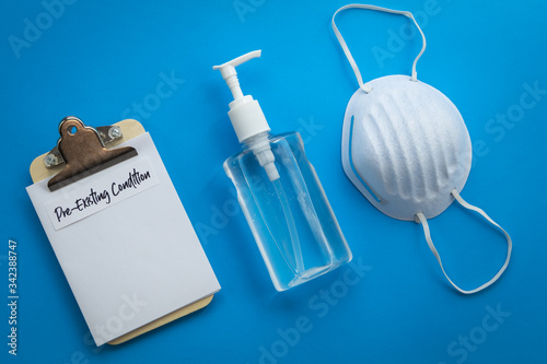 Pre-Existing Condition healthcare concept with mask and hand sanitizer, flat lay 