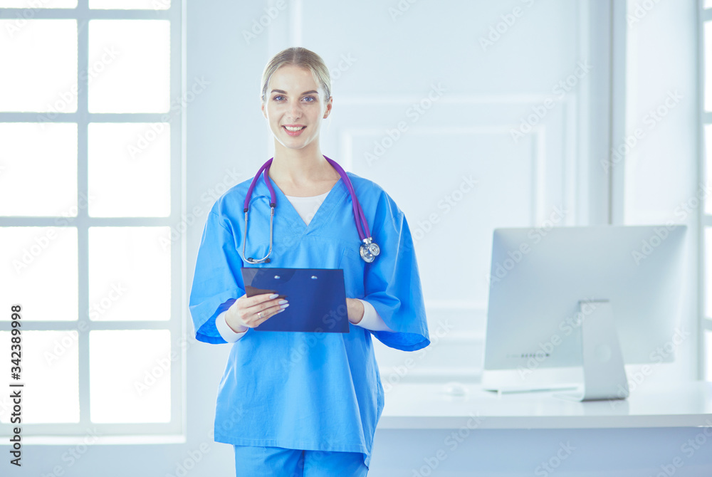 Smiling female doctor with a folder in uniform standing Smiling female doctor with a folder in uniform standing