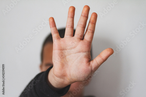 close up view of a kid showing his hand palm - stop gesture