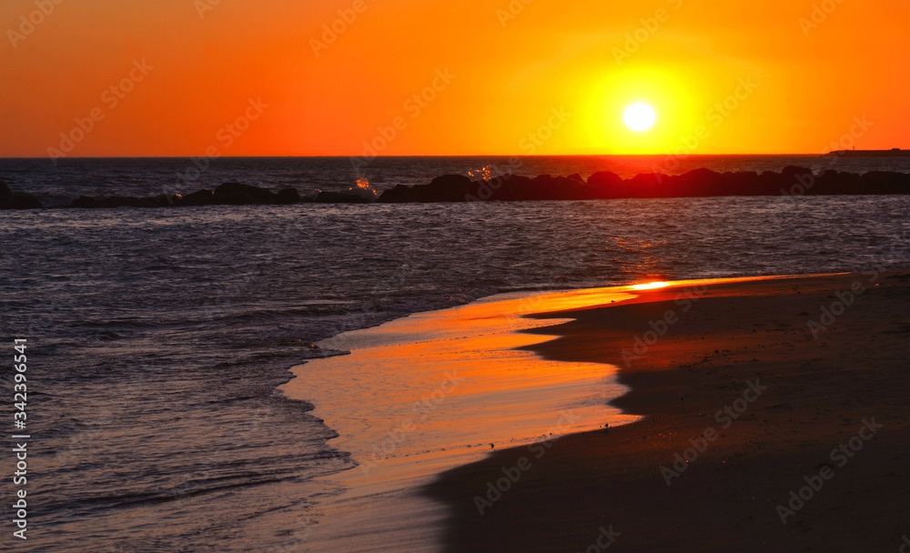 Naklejka premium Orange Sunset Seascape with Mollarella sand beach (spiaggia di mollarella) near coastal city of Licata , SICILY Italy