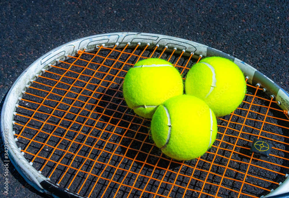 Tennis balls lie on a tennis racket