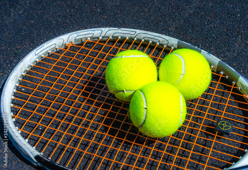 Tennis balls lie on a tennis racket © Nariman