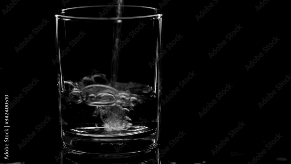 Closeup pouring clean fresh Water in a Glass with splash and bubbles, isolated on Black background. Ice, bubbles and splash. Cold tonic Mineral water. Healthy lifestyle. Living water. Drinking water. Closeup pouring clean fresh Water in a Glass with splash and bubbles, isolated on Black background. Ice, bubbles and splash. Cold tonic Mineral water. Healthy lifestyle. Living water. Drinking water.