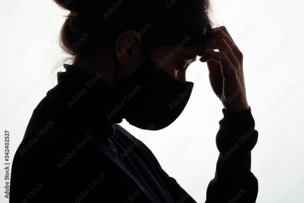 silhouette profile of young woman thinking in protective mask on white studio background, figure of pensive girl, concept health and safety, epidemic problem
