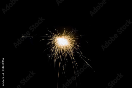 firework sparkles with light trail with bright orange light with black isolated background