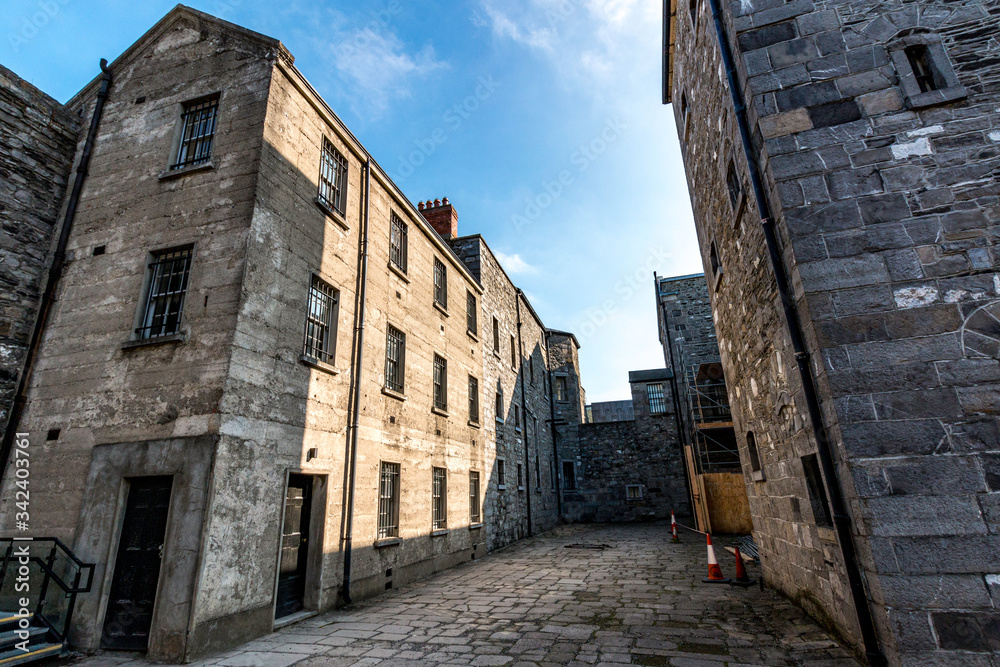 A historic old Prison architecture building in Ireland with rooms, doors, windows with blue sky.