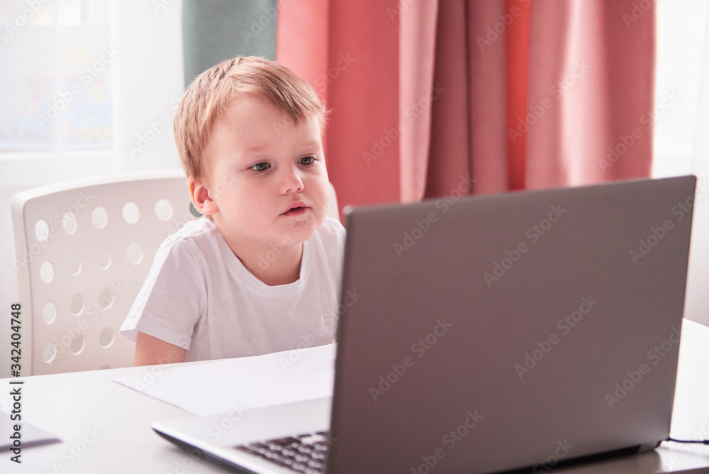 Smiling boy with a laptop. Online lessons Smiling boy with a laptop. Online lessons