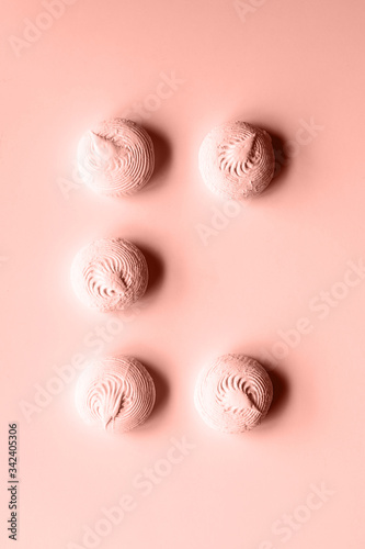 Five coral sweet dessert zephyr marshmallows on pink background with one missing  abcent  having place for it  lost.