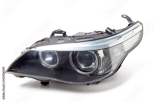 Stylish headlight of a German car with transparent glass - optical equipment with a lamp inside on a white isolated background. Spare part for auto repair in a car workshop. photo