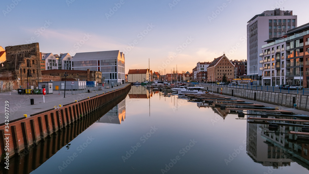 View of city Gdansk at sunrise. The promenade along the riverbank of Motlawa River and a marina.